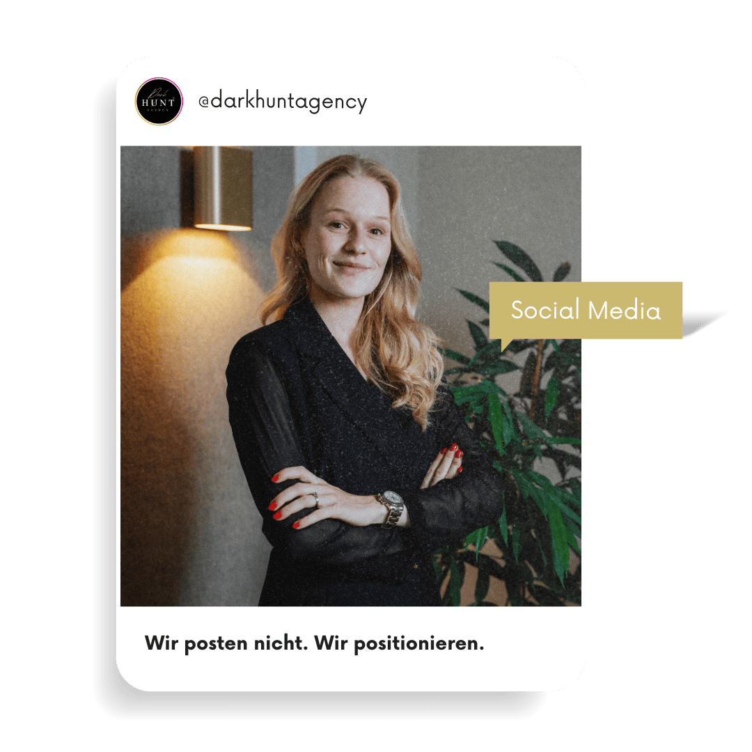 Charlotte mit verschränkten Armen lächelt selbstbewusst vor einer Wandlampe und Pflanzen – Social Media Positionierung.